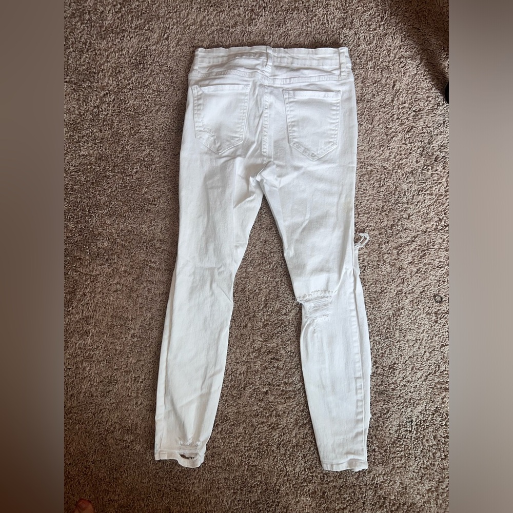 White pair of size 7 Cello jeans with holes